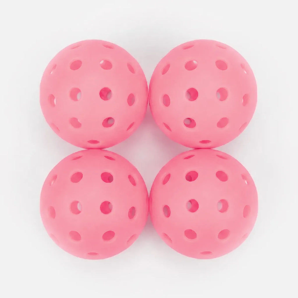 Four pink perforated balls on a white background